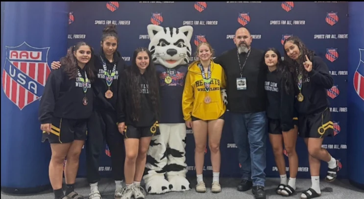 Girls wrestlers and coach together with their medals at the AAU Scholastic Duals
